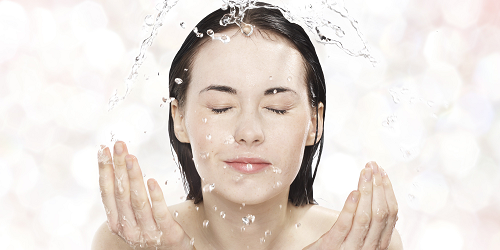 Woman splashing water onto her face